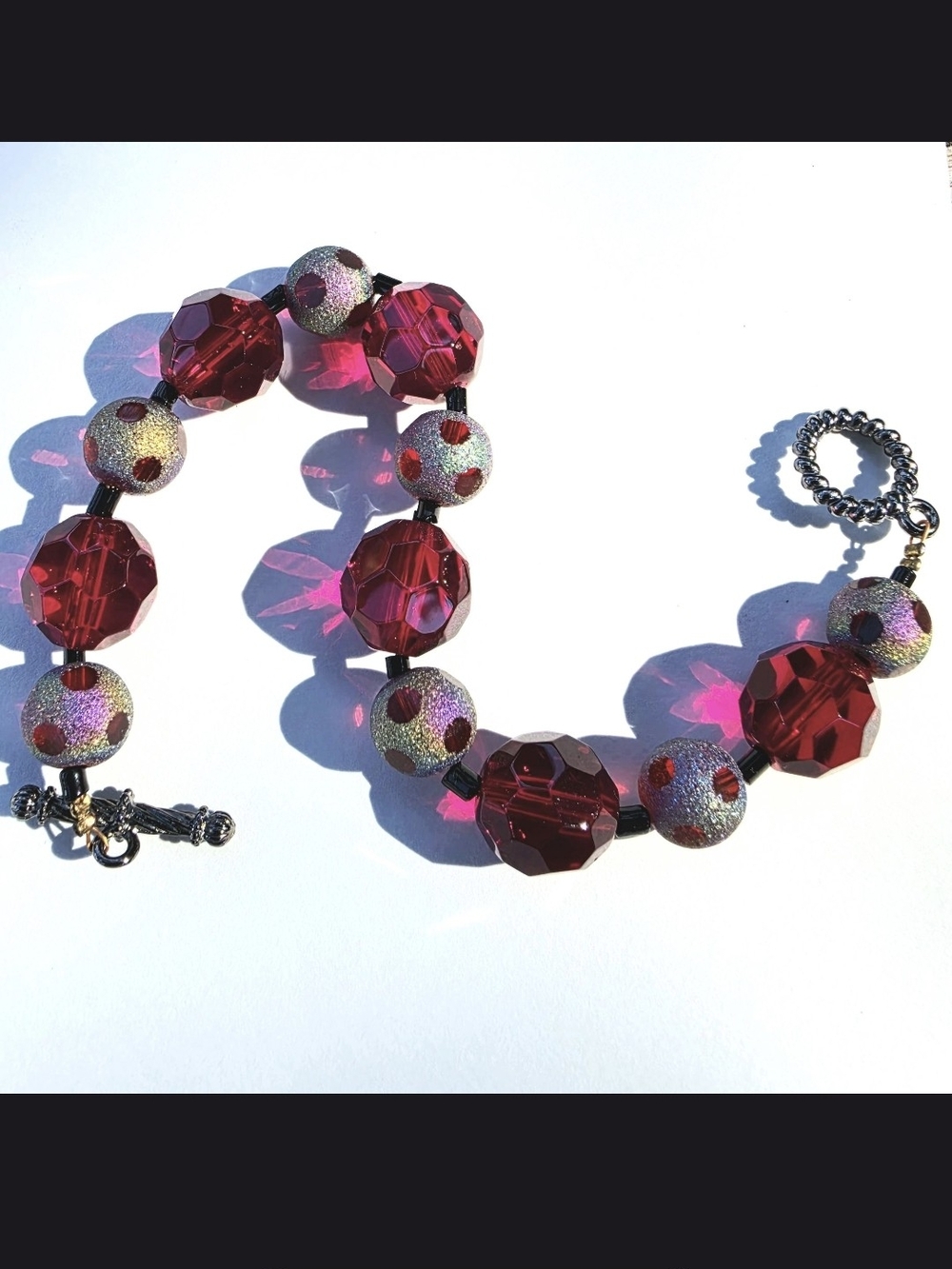 Handmade faceted glass beaded bracelet with toggle clasp - red irridescent polka